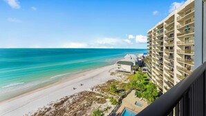 Un hôtel situé en bord de mer, doté de nombreux balcons offrant une vue sur l’océan.