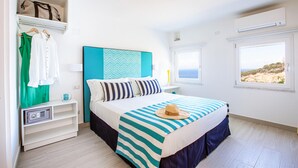 Un dormitorio con cama, mesita de noche, armario y ventana con vistas.