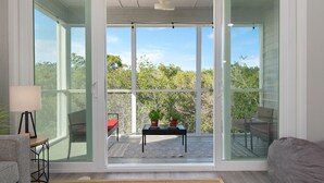 A modern living room with large sliding glass doors leading to an outdoor patio. - ⚓The Tree House! Beautiful townhome in Longboat Key with great amenities surrounded by nature!⚓ (Longboat Key)