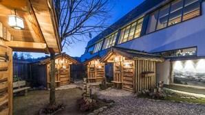 A wooden cabin-style building with a gravel courtyard, wooden fences, and a view of the mountains. - Vacation apartment Bruneck, ideal for bikers & hikers, garage, Cron 4 sauna & pool (Brunico)