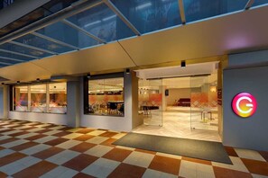 A hotel entrance with a checkered floor, glass doors, and a visible interior with tables and chairs. - Ginger Vishakhapatnam Gajuwaka (Visakhapatnam)