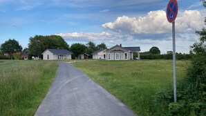 Een landweg die leidt naar een rij huizen, met een parkeerverbod.