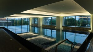 A modern indoor swimming pool with large windows and a high ceiling. - Gateway Ahmedabad Sindhu Bhavan (Ahmedabad)