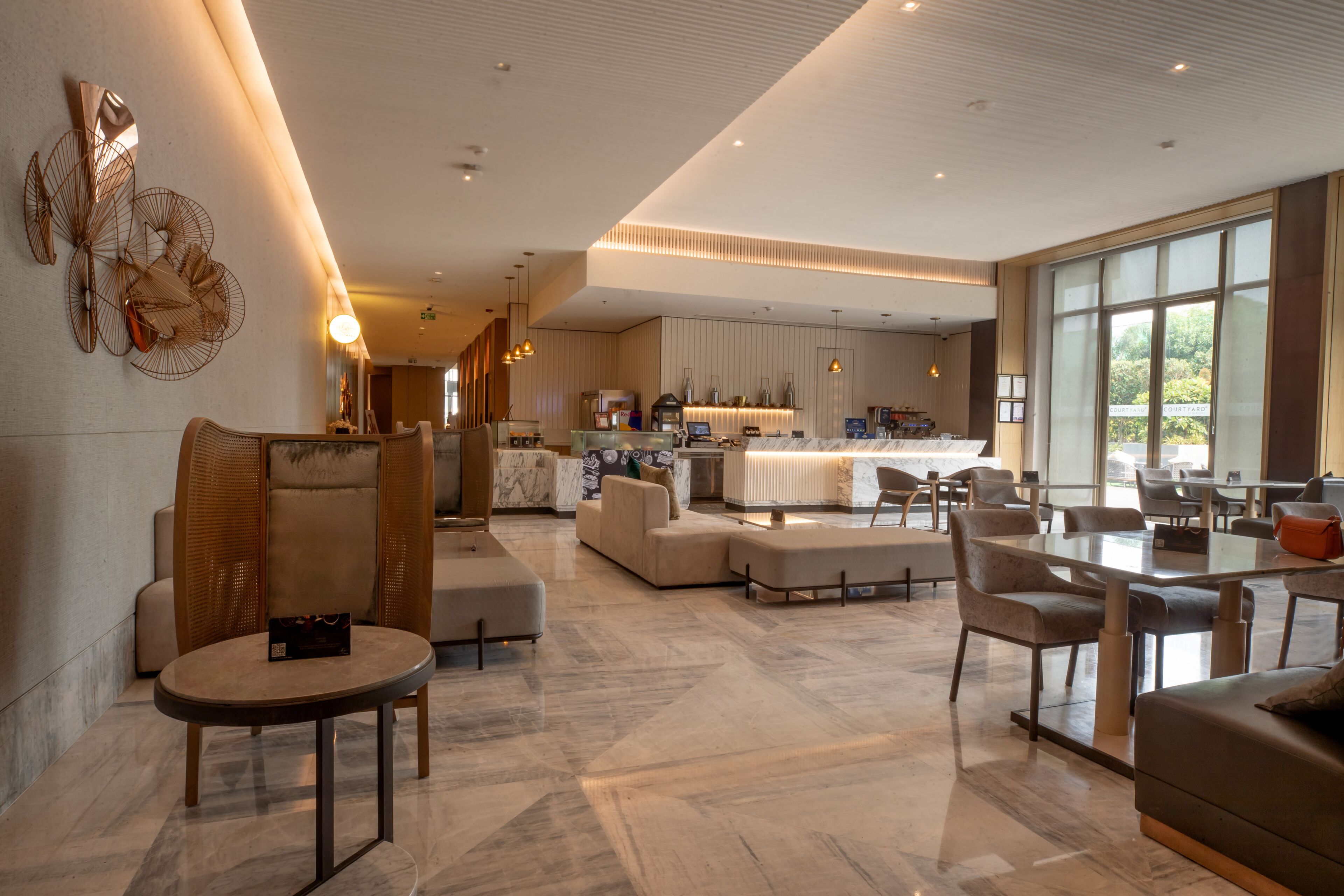 A spacious, modern living area with a large kitchen in the background, featuring a dining table and comfortable seating.