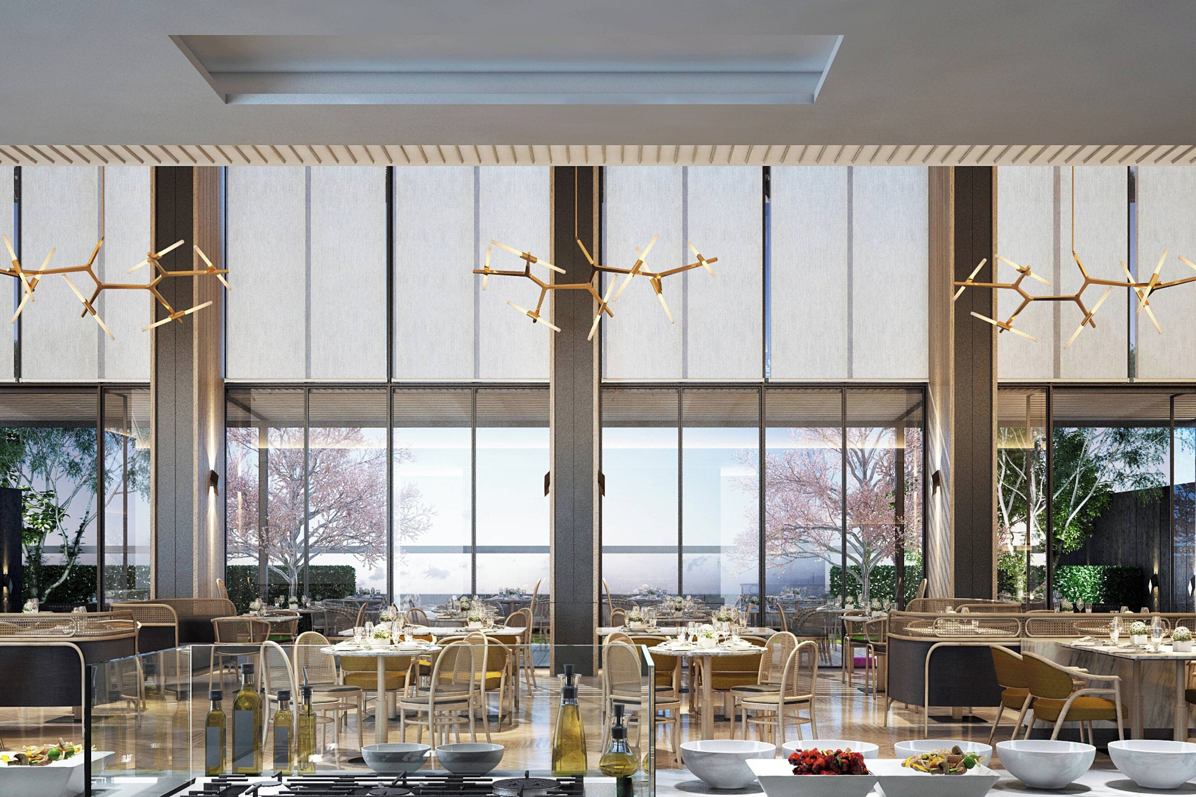 A spacious dining area with high ceilings and large windows, featuring modern furniture and a unique chandelier design.