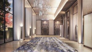 A modern hotel lobby with a large patterned carpet, wooden flooring, and a unique ceiling light fixture. - Gateway Ahmedabad Sindhu Bhavan (Ahmedabad)