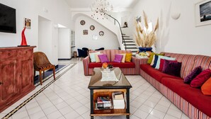 A spacious living room with a red sofa, a wooden coffee table, and a staircase leading to another level. - I giardini dell'Eden, Pool Amalfi Villa, jacuzzi, stunning view, garden, parking (Amalfi)