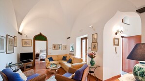 A spacious living room with a large sofa, a television, and a dining area with a table and chairs. - Mille e una notte Luxury Villa With Stunning Sea View and private pool (Conca dei Marini)