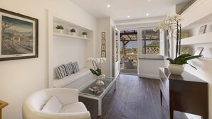 A modern living room with a glass coffee table, a white sofa, and a painting on the wall. - La rosa, Luxury villa private pool Equipped With Conforts, wide garden,parking (Sorrento)