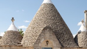 Um edifício de pedra com telhado cónico e uma placa com o nome 'Lucia'.