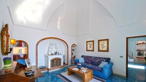 Ein geräumiges Wohnzimmer mit Kamin, einem blauen Sofa und einem Couchtisch.