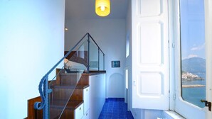 Een trap met glazen balustrade die uitkomt op een plateau met een kunstwerk in een lijst.