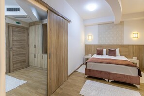 Un dormitorio con una cama, un armario de madera y una mesita de noche con lámpara.