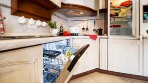 Una cocina moderna con muebles blancos, lavavajillas y microondas.
