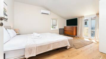 A bedroom with a bed, a dresser, a window, and a balcony.