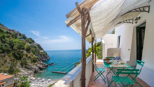 A balcony with a view of the sea, a table with chairs, and a hanging chair. - Casa di mare, Exclusive Property on the beach, private terraces, stanning views (Maiori)