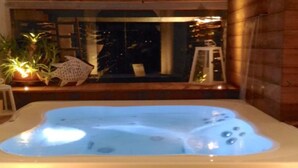 A hot tub with a view of a balcony and a Christmas tree. - Villa Cindarella, Exclusive Property in Positano, private jacuzzi, near beach! (Positano)
