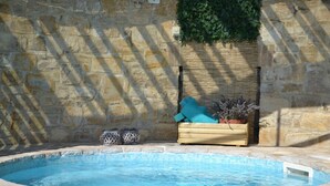 A stone wall with a wooden planter box containing lavender plants and a blue cushion. - Noce, Characteristic chalet in Umbria with SPA, jacuzzi, garden, stunning view. (Piedicolle)