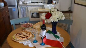 A dining table with a pie, wine, glasses, and a vase with flowers. - Noce, Characteristic chalet in Umbria with SPA, jacuzzi, garden, stunning view. (Piedicolle)