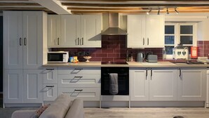 A modern kitchen with grey cabinets, a microwave, a stove, and a dishwasher.