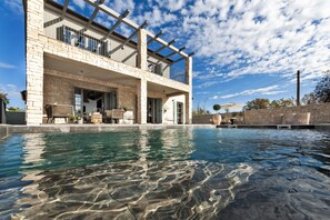 Un edificio moderno de dos pisos con una piscina delantera.