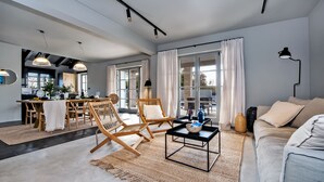 A spacious living area with a dining table, two wicker chairs, a black coffee table, and a sofa. - Villa Renata with Pool and Sauna (Kanfanar)