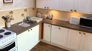 Efficient kitchen with double sink, stove, and microwave.