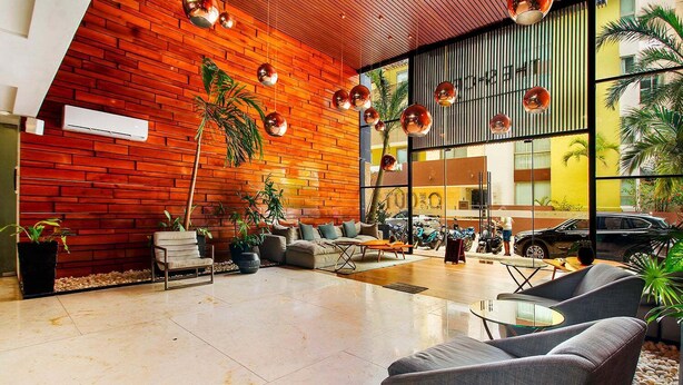 Um lobby moderno com parede de tijolos, área de estar e grandes janelas.