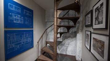 Eine Wendeltreppe mit blauen Architektenplänen an der Wand.