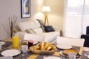 Enjoy a peaceful dining experience in this inviting space, complete with a comfortable sofa, modern lamp, and beautifully set table.