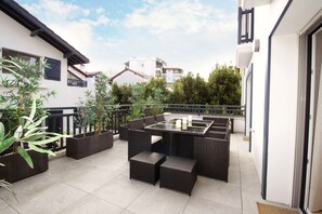 Relax on the patio surrounded by lush greenery and comfortable seating.