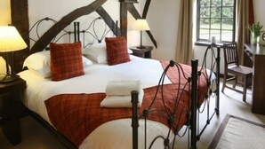 Hotellihuone, jossa on suuri sänky, työpöytä ja tuoli.