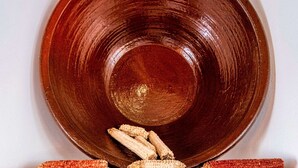 A large, round, brown ceramic plate with a glossy finish, placed on a wooden surface against a plain background. - Two-level marvel in exotic fruit orchard (Ribeira Grande)