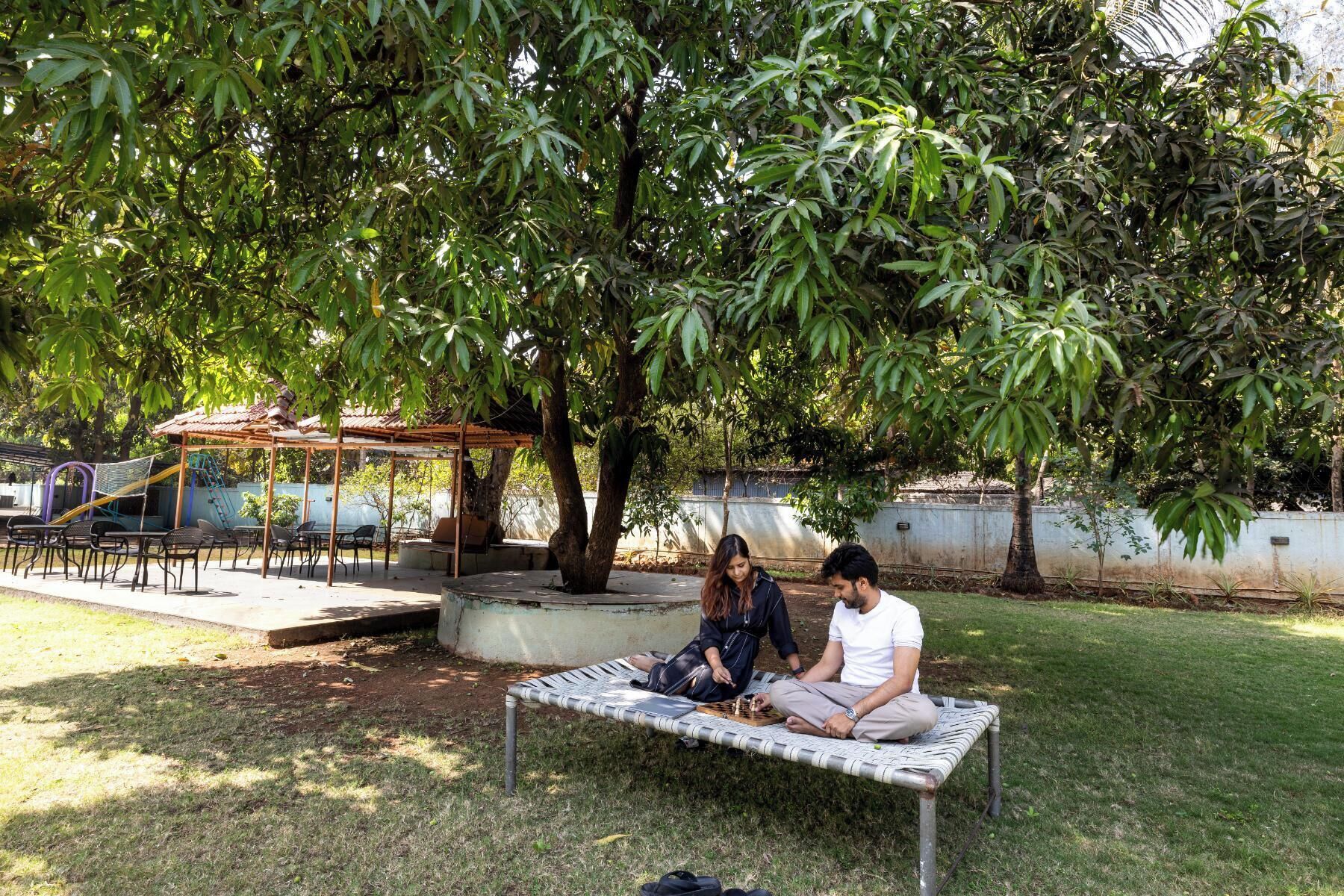 Un parque con un banco de metal, una zona de estar techada y un área de juegos.