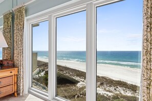 A room with a large window offering a view of a beach and ocean. - Beachfront Bliss at Tops'l Goin' Coastal | Stunning Views & Resort Amenities! Beach Manor 710 (Miramar Beach)
