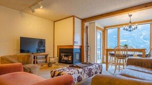 Una sala de estar acogedora con chimenea, televisor y asientos cómodos.