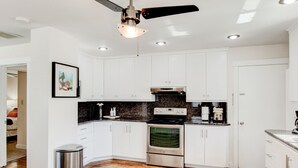 A modern kitchen with white cabinets, a stainless steel oven, and a black countertop. - Anna's Alley Cute top floor 3 BD/ House Heart of SLC (Murray)