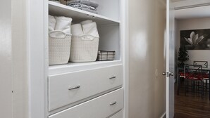 A hallway with a white storage unit, wooden flooring, and a dining area with a red table and chairs. - Anna's Alley Cute top floor 3 BD/ House Heart of SLC (Murray)