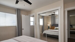 A bedroom with a bed, a ceiling fan, a window with blinds, and a door leading to another room. - Anna's Alley Cute top floor 3 BD/ House Heart of SLC (Murray)