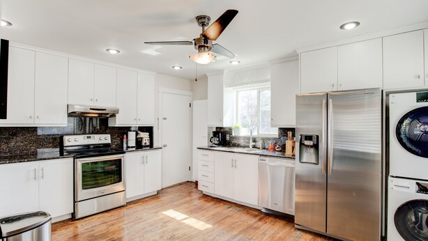 A modern kitchen with white cabinets, stainless steel appliances, a built-in oven, a dishwasher, and a ceiling fan. - Anna's Alley Cute top floor 3 BD/ House Heart of SLC (Murray)