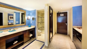 Une salle de bain moderne avec un grand miroir, deux lavabos, une douche et des toilettes.