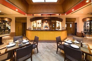 Un restaurant doté d’un bar central, de plusieurs tables et de chaises.