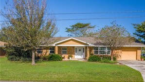 A single-story house with a front porch, a garage, and a well-maintained lawn. - A perfect place in Central Florida for boating, fishing, or a relaxing vacation! (Lake Wales)