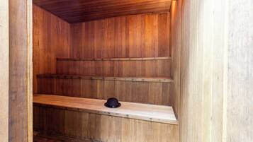 Un intérieur en bois avec des étagères intégrées et un chapeau noir posé sur l’une d’elles.
