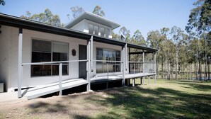 A modern two-story house with a covered porch and a small deck. - Amazing, secluded twenty-five acre property - yet close to everything you need! (Lovedale)