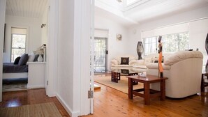 A spacious living room with a white sofa, a coffee table, and a ceiling fan.