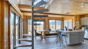 Une cuisine moderne avec des murs en bois, un îlot central et un escalier en colimaçon.
