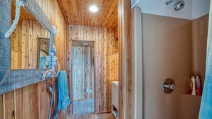Un intérieur en bois avec un miroir, un porte-serviettes et un espace douche.