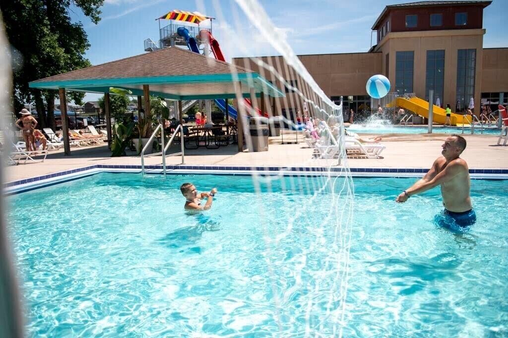 A swimming pool with a water slide and a children's play area.