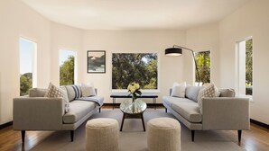 A modern living room with two sofas, a round coffee table, and a bench. - Stunning, Private Home With Pool, Hot Tub, and Mountain Views! (Santa Barbara)